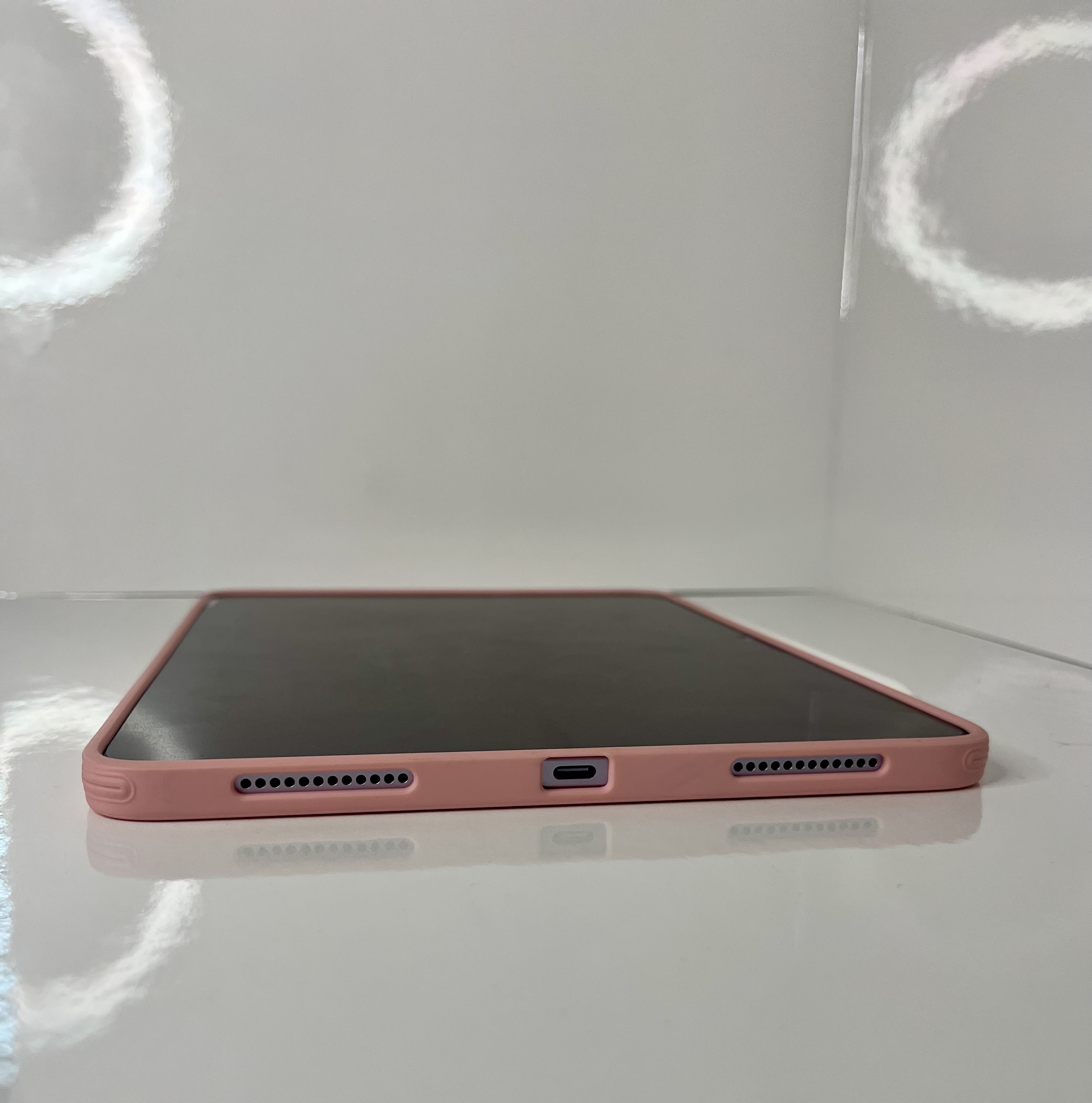 A low-angle shot of the iPad highlights its charging port and speaker grills along the bottom edge.